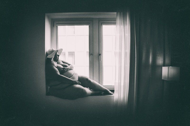 Schwarzweiß-Bild von Rebecca in Unterwäsche auf dem Fensterbrett